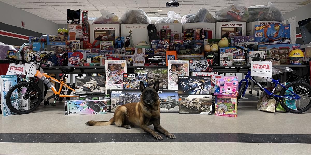 K9 Leo poses in front of all the toys that were donated through the Toys for Tots donation event.